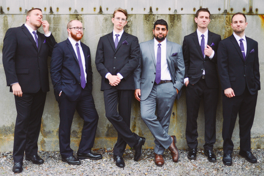 A man and his groomsmen stand outside the Foundry at Puritan Mill