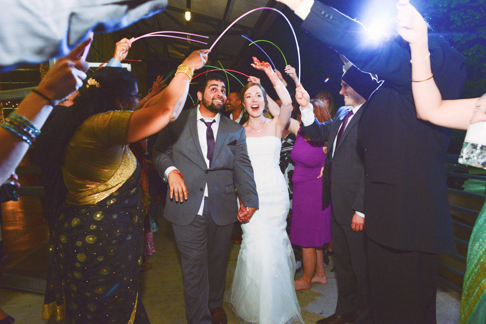 A couple exit their wedding at the Foundry at Puritan Mill